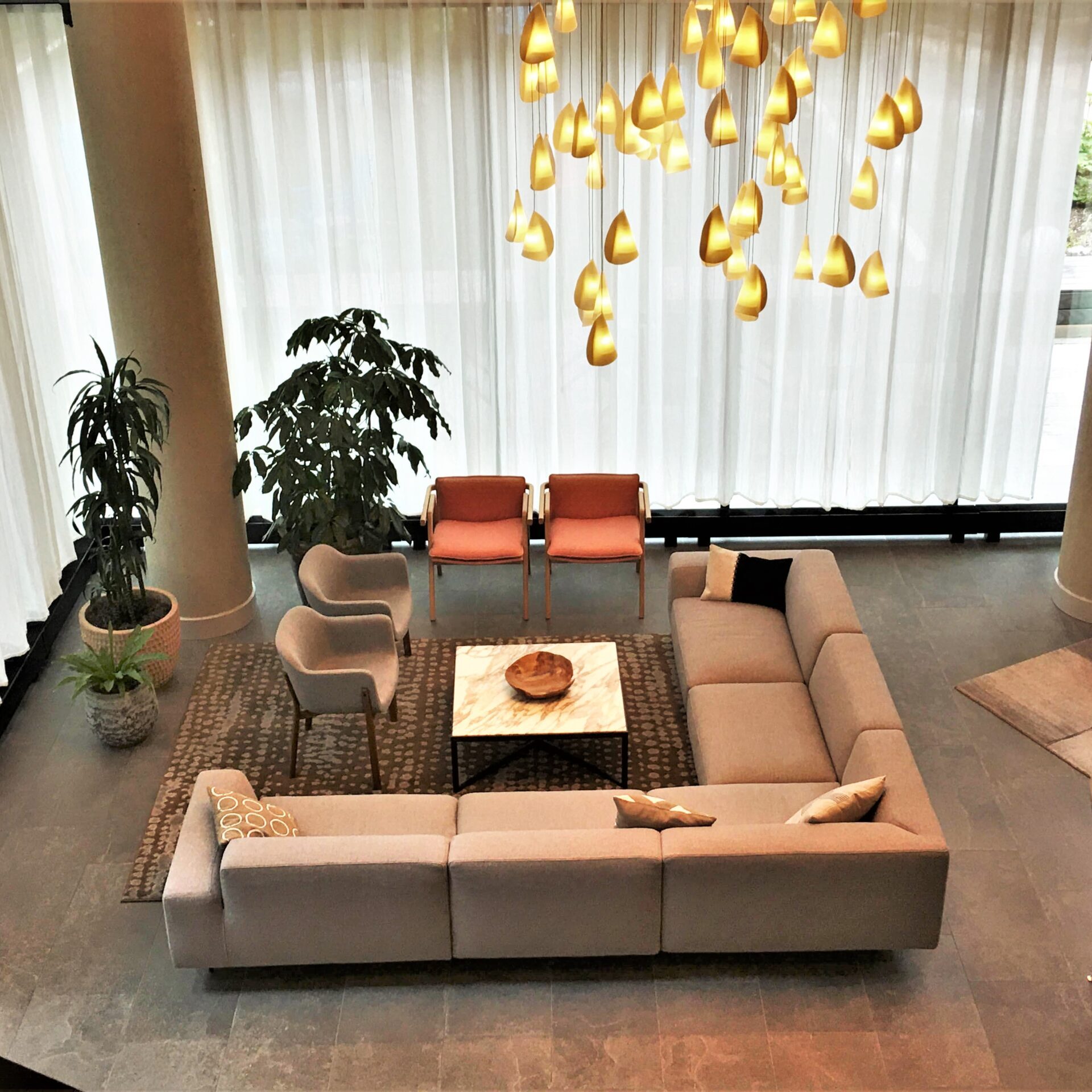 Modern living room with L-shaped sofa and elegant lighting.